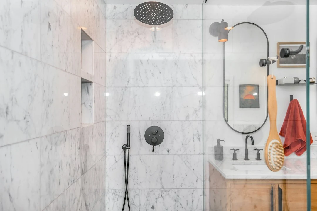 Bouchon de cheveux dans une douche italienne avec eau qui stagne près de la bonde