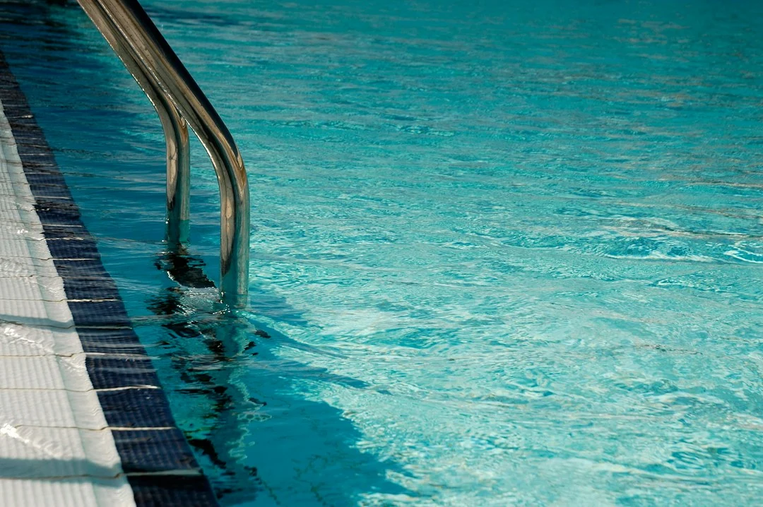 Technicien réalisant une détection de fuite sur piscine avec matériel spécialisé
