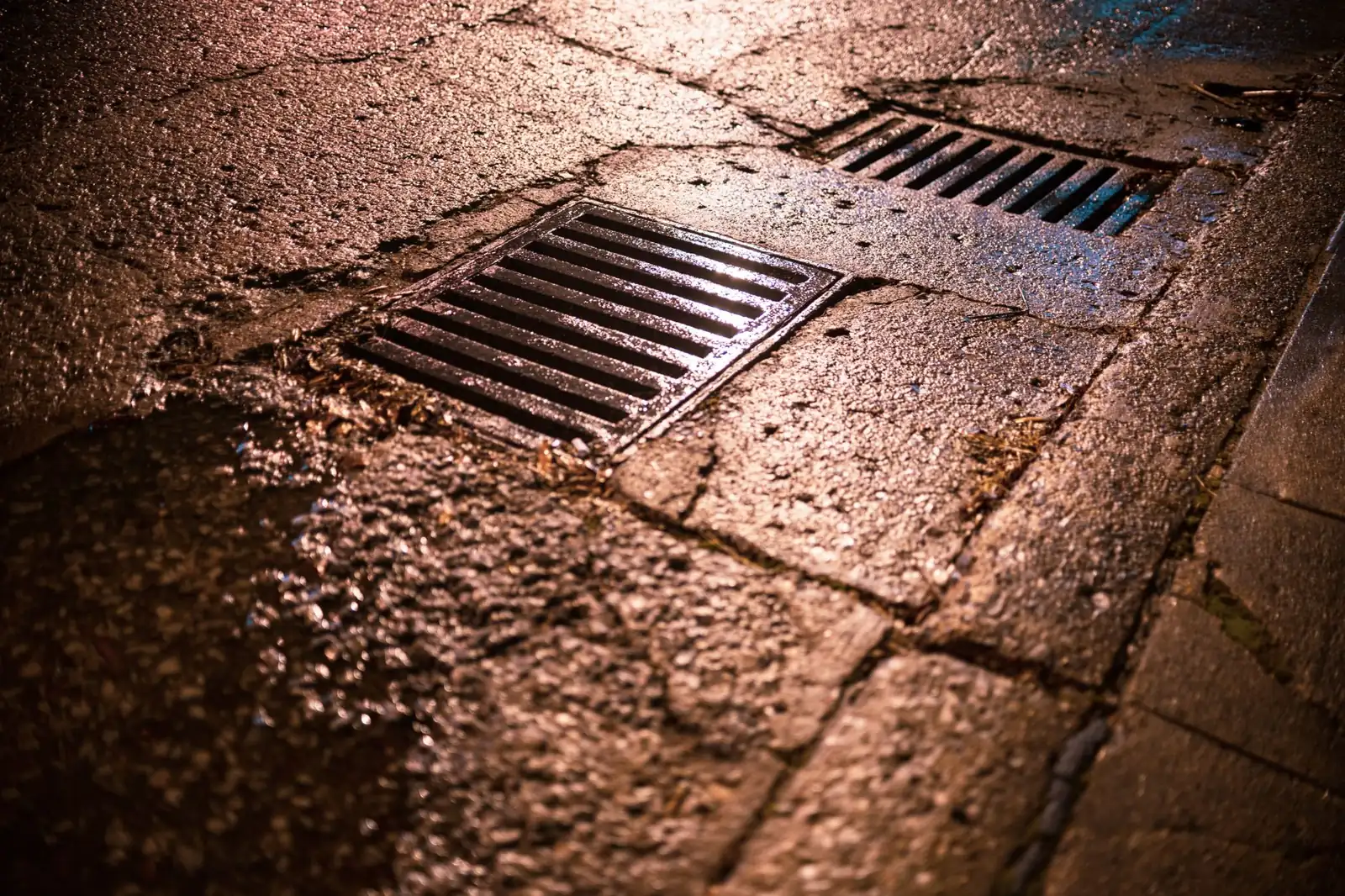 Regard eaux pluviales bouché après orage avec eau de pluie stagnante dans une cour